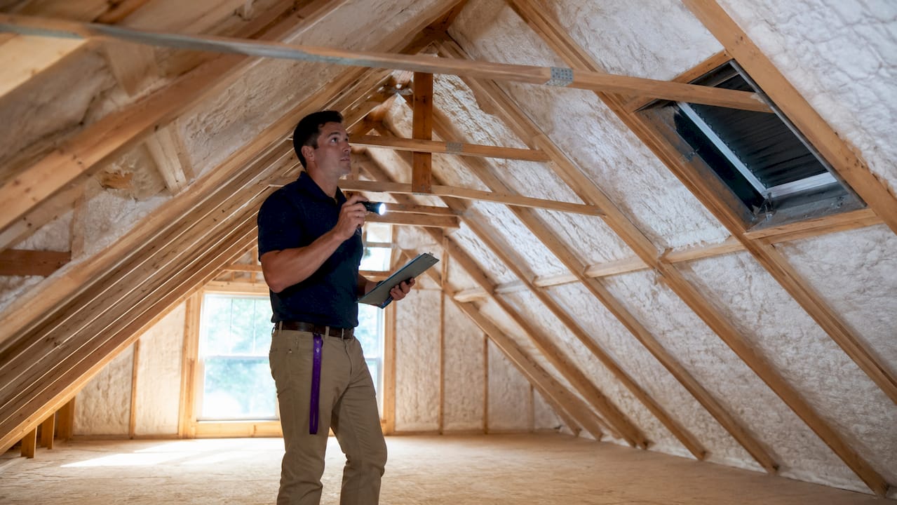 Home inspector examining attic convection airflow