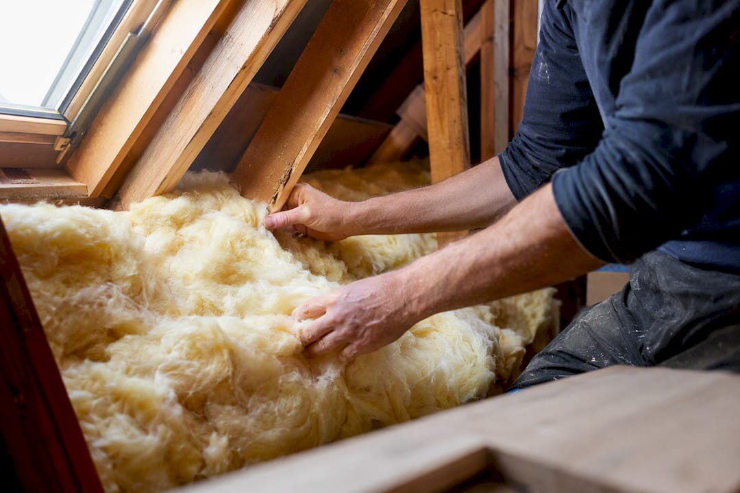 1787035113429_Hands-installing-fiberglass-batt-insulation Hands installing fiberglass batt insulation
