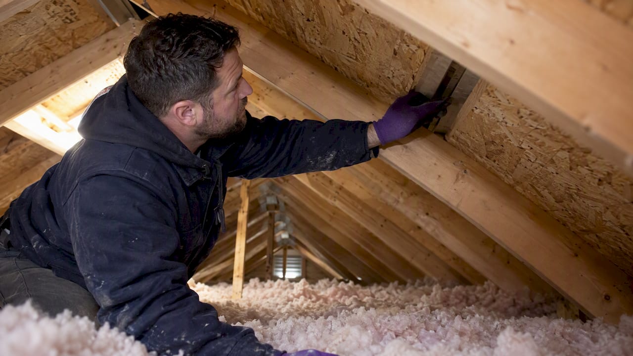 Technician checking an open attic ventilation channel