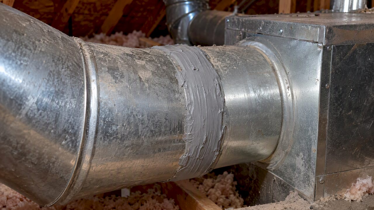 Mastic seals a metal attic duct seam